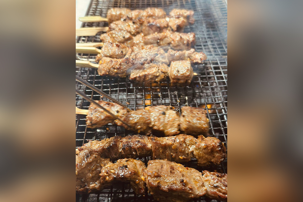 Robata grilled beef skewers cooking over charcoal